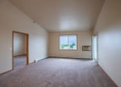 Thumbnail 30 of 61 - an empty living room with carpet and a window. Fargo, ND West Lake Apartments