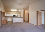 Thumbnail 31 of 61 - an empty living room and kitchen with an open door. Fargo, ND West Lake Apartments