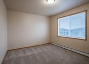 Thumbnail 43 of 61 - a bedroom with a large window and carpet. Fargo, ND West Lake Apartments