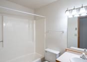 Thumbnail 24 of 25 - a bathroom with a toilet and a sink and a mirror. Fargo, ND Westview Towers Apartments