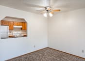 Thumbnail 20 of 25 - an empty room with a ceiling fan and a kitchen. Fargo, ND Westview Towers Apartments