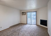 Thumbnail 17 of 25 - an empty living room with a fireplace and a sliding glass door. Fargo, ND Westview Towers Apartments