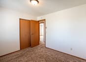 Thumbnail 11 of 25 - a bedroom with a carpeted floor and a door to a closet. Fargo, ND Westview Towers Apartments