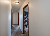 Thumbnail 16 of 25 - a hallway with a closet and a mirror in a house. Fargo, ND Westview Towers Apartments