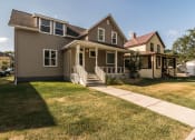 Thumbnail 2 of 7 - Grand Forks, ND Faul 4 Plex. A home with a green lawn and a brown house in the background