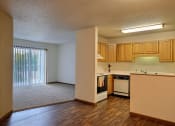 Thumbnail 9 of 23 - A living room with a glass sliding door and kitchen. Fargo, ND Flagstone Apartments.