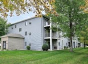 Thumbnail 23 of 23 - An exterior of a three level apartment with a large grass area out front. Fargo, ND Flagstone Apartments.