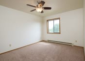 Thumbnail 14 of 18 - a bedroom with a ceiling fan and a window. Fargo, ND Flickertail Apartments