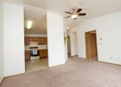 Thumbnail 13 of 18 - a living room with a ceiling fan and a kitchen. Fargo, ND Flickertail Apartments