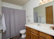 Thumbnail 10 of 18 - a bathroom with a shower and a sink and a toilet. Fargo, ND Flickertail Apartments