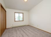 Thumbnail 8 of 18 - a bedroom with carpet and a window. Fargo, ND Flickertail Apartments