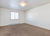 Thumbnail 9 of 15 - a living room with a window and carpet. Fargo, ND Foxtail Townhomes