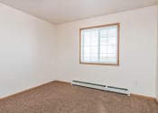 Thumbnail 11 of 15 - a bedroom with a window and carpet. Fargo, ND Foxtail Townhomes