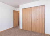 Thumbnail 12 of 15 - an empty bedroom with a closet and a door to a hallway. Fargo, ND Foxtail Townhomes