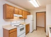 Thumbnail 6 of 15 - a kitchen with white appliances and wooden cabinets. Fargo, ND Foxtail Townhomes