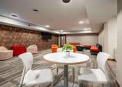 Thumbnail 29 of 32 - a meeting room with a round table and chairs. Fridley, MN Georgetown on the River Apartments