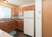 Thumbnail 7 of 13 - a kitchen with a stove refrigerator and sink. Fargo, ND White Ridge Apartments