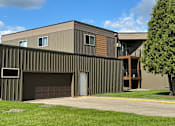 Thumbnail 17 of 17 - A modern house with a garage door and a tree in front. Grand Forks, ND Cedarwood Apartments