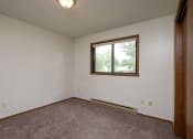 Thumbnail 8 of 9 - a bedroom with a window and a carpeted floor. Fargo, ND Gemstone Apartments