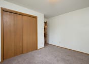 Thumbnail 9 of 9 - a bedroom with a closet and a door to a hallway. Fargo, ND Gemstone Apartments