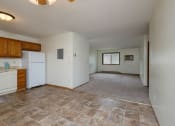 Thumbnail 6 of 9 - a kitchen with a living room with windows in the background. Fargo, ND Gemstone Apartments