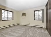 Thumbnail 10 of 32 - Fridley, MN Georgetown Apartments. A bedroom with two windows and a carpeted floor