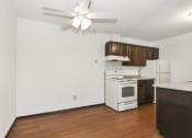 Thumbnail 8 of 32 - Fridley, MN Georgetown Apartments. A kitchen with white appliances and wooden cabinets