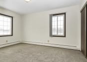 Thumbnail 19 of 32 - a bedroom with two windows and a carpet. Fridley, MN Georgetown on the River Apartments