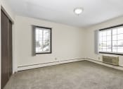 Thumbnail 21 of 32 - a bedroom of an empty house with carpet and two windows. Fridley, MN Georgetown on the River Apartments
