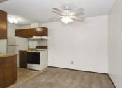 Thumbnail 18 of 32 - an empty kitchen with a ceiling fan and a white refrigerator. Fridley, MN Georgetown on the River Apartments