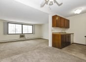 Thumbnail 15 of 32 - a  living room with a kitchen and a window. Fridley, MN Georgetown on the River Apartments