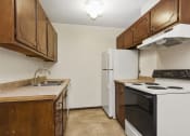 Thumbnail 16 of 32 - a kitchen with a stove refrigerator and sink. Fridley, MN Georgetown on the River Apartments