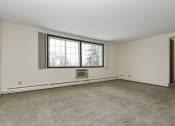 Thumbnail 13 of 32 - the living room of an empty house with a large window. Fridley, MN Georgetown on the River Apartments