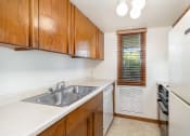 Thumbnail 6 of 19 - a kitchen with a sink and a refrigerator and wooden cabinets.  Golden Valley, MN Valley View Apartments