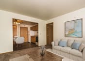 Thumbnail 1 of 11 - Apartment a living room with a couch and coffee table with a dining room in the background  at Amberwood Court, Grand Forks, ND, 58201