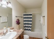 Thumbnail 15 of 16 - Grand Forks, ND Autumn Apartments. A bathroom with a sink, toilet, and a bathtub.
