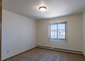 Thumbnail 13 of 16 - a bedroom with a window. Grand Forks, ND Autumn Ridge Apartments