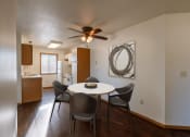 Thumbnail 3 of 16 - a dining area with a table and chairs and a ceiling fan. Grand Forks, ND Autumn Ridge Apartments