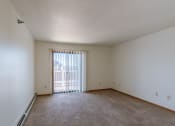 Thumbnail 8 of 16 - an empty living room with a sliding glass door to a balcony. Grand Forks, ND Autumn Ridge Apartments