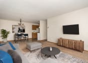 Thumbnail 2 of 7 - Grand Forks, ND Barrette Arms Apartments. a living room with a couch a table and a chair and a television on the wall