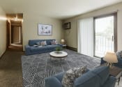 Thumbnail 1 of 11 - Grand Forks, ND Carling Manor Apartments.  a living room with two couches and a coffee table in front of a sliding glass door
