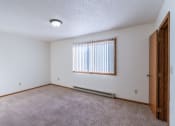 Thumbnail 11 of 14 - a bedroom with carpet and a window. Grand Forks, ND Cedarwood Apartments