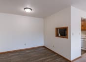 Thumbnail 10 of 14 - the living room and dining room of an apartment with a wood floor and white walls. Grand Forks, ND Cedarwood Apartments
