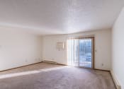 Thumbnail 6 of 14 - an empty living room with a sliding glass door to a balcony. Grand Forks, ND Cedarwood Apartments