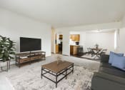 Thumbnail 1 of 11 - Grand Forks, Chandler 1802 Apartments.  A living room with a couch a coffee table and a tv and a dining room and kitchen in the background