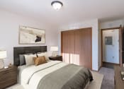Thumbnail 3 of 7 - a bedroom with a bed and a closet and a door to a bathroom. Grand Forks, ND Chandler 1898 Apartments