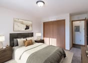 Thumbnail 4 of 19 - a bedroom with a bed and a closet and a door to a bathroom. Grand Forks, ND Chandler 1866 Apartments