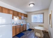 Thumbnail 2 of 7 - a kitchen with a dining table and a refrigerator. Grand Forks, ND Chandler 1898 Apartments
