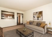 Thumbnail 6 of 19 - Grand Forks, Chandler 1802 Apartments.  A living room with a couch, coffee table, and kitchen in the background