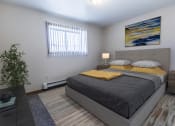 Thumbnail 4 of 19 - Grand Forks, ND Cherry Creek Apartments. A bedroom with a bed, window, and a nightstand